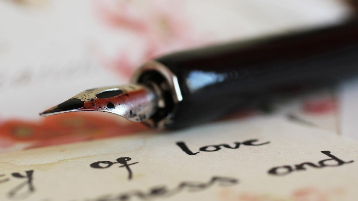 Gros plan sur une plume de stylo posée sur une feuille manuscrite, illustrant l’écriture d’une biographie d’auteur avec une calligraphie élégante.