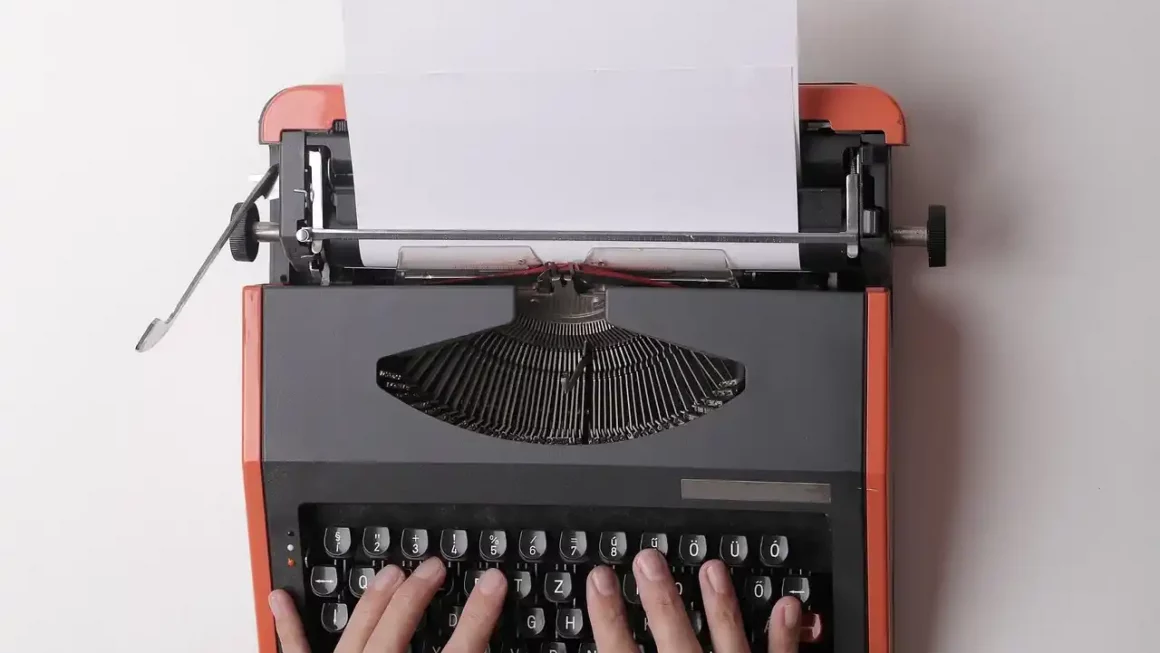 Un auteur en train de taper à la machine à écrire, illustrant l'importance du copywriting en 2025 pour se connecter avec son public. L'article explore les 5 tendances majeures du copywriting à suivre cette année : l'authenticité, l'usage de l'IA, le SEO, l'intégration de contenu visuel et l'engagement émotionnel, afin d'optimiser la communication et la promotion des livres.