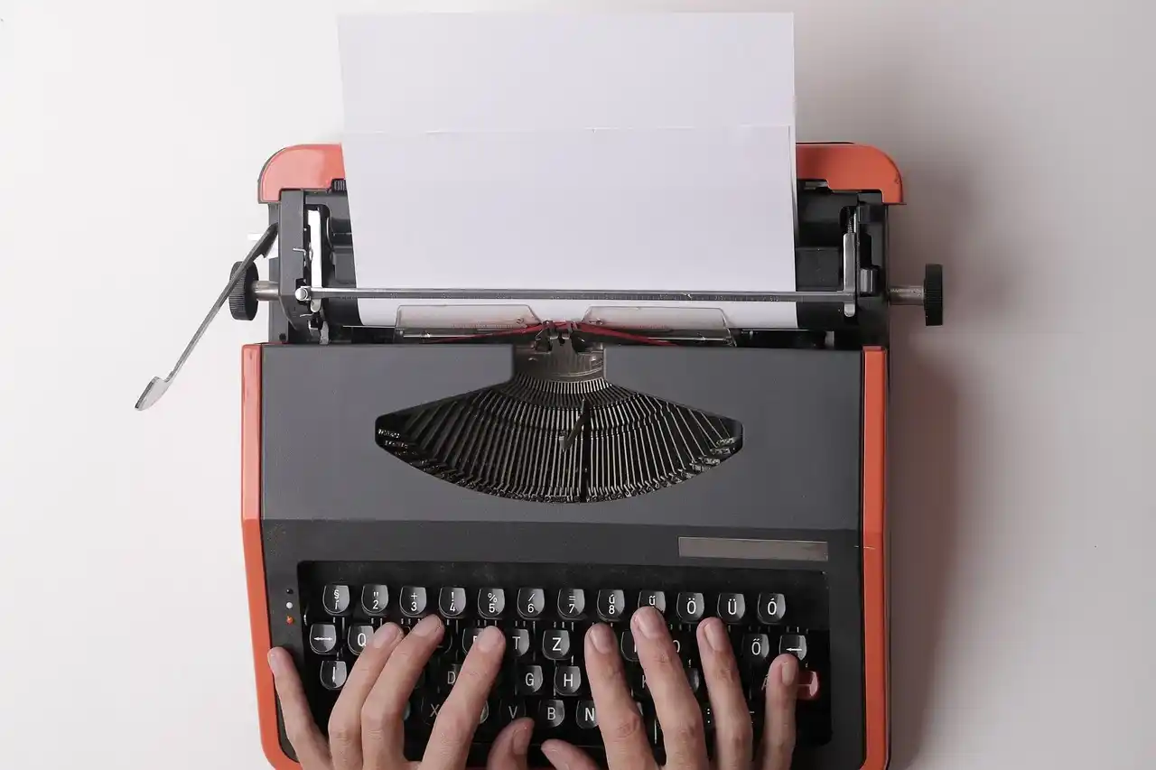 Un auteur en train de taper à la machine à écrire, illustrant l'importance du copywriting en 2025 pour se connecter avec son public. L'article explore les 5 tendances majeures du copywriting à suivre cette année : l'authenticité, l'usage de l'IA, le SEO, l'intégration de contenu visuel et l'engagement émotionnel, afin d'optimiser la communication et la promotion des livres.