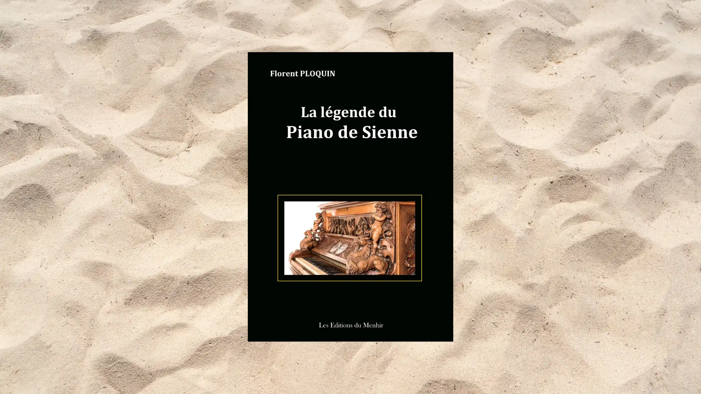 Couverture du livre La légende du Piano de Sienne de Florent Ploquin, publié aux Éditions du Menhir. L’image montre un piano richement sculpté, photographié sur un fond de sable, symbolisant le voyage et la mémoire.