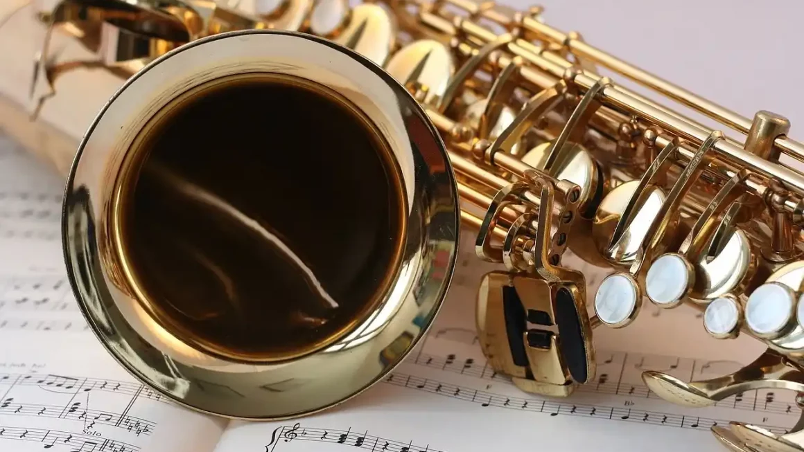Saxophone doré posé sur des partitions musicales – symbole de la diversité des instruments célébrés lors de l'Histoire de la Fête de la Musique.