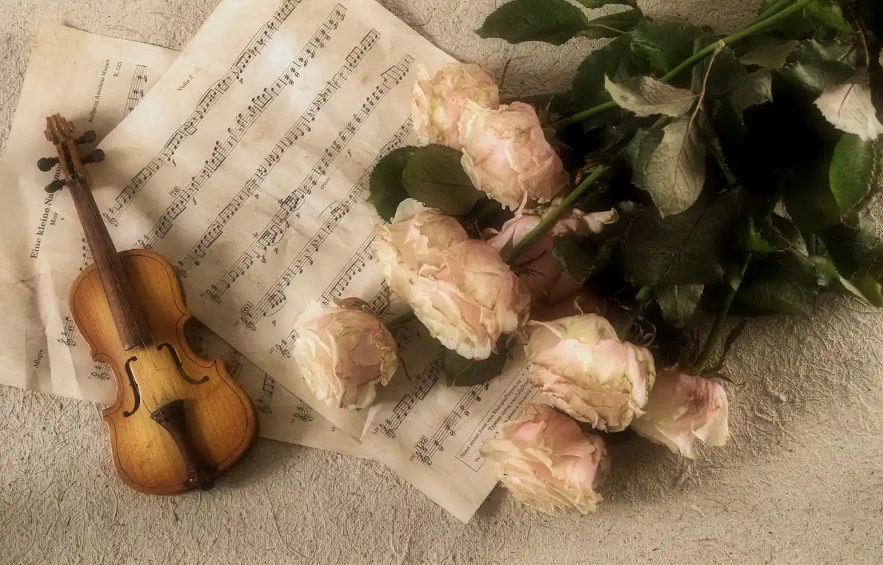 Partition musicale, violon miniature et roses, illustrant l’impact de l’intelligence artificielle dans la musique sur la créativité et l’art musical.