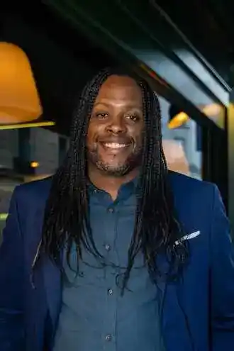 Portrait de Yannick Laristan, client souriant en costume bleu, photographié en intérieur, satisfait de son accompagnement avec Charlène Rédac’.