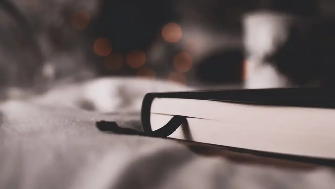 Livre ouvert posé sur un lit, ambiance douce et littéraire – illustration de l’article sur le SEO et l’IA pour auteur et éditeur, expliquant comment allier stratégie numérique et création littéraire.