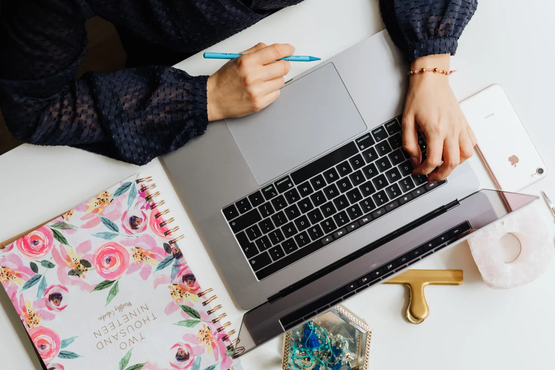 Auteure organisant sa stratégie de visibilité en ligne sur son MacBook pour améliorer son SEO compte auteur.