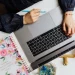 Auteure organisant sa stratégie de visibilité en ligne sur son MacBook pour améliorer son SEO compte auteur.